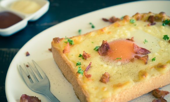 Egg Yolk Bacon Ham Cheese Toast and Coriander. Breakfast egg yolk bacon ham cheese with bread toast with coriander on top for food and drink category