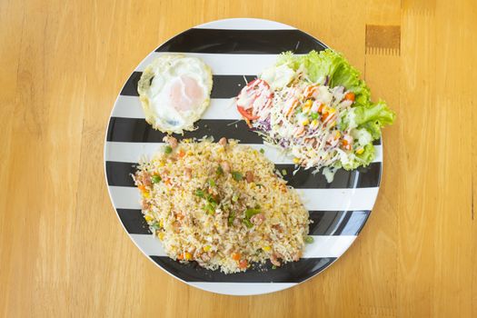 Thai Sour Pork Fried Rice and Salad and Fried Egg in Dish on Wood Table on Top View or Flatlay View