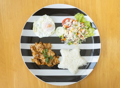 Fried Chicken with Garlic and Pepper and Fried Egg and Vegan Salad and Rice in Dish on Wood Table with Natural Light on Flatlay View