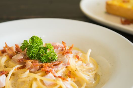 Spaghetti Carbonara with Bacon and Ham and Parsley and Mayonnaise Sauce. Spaghetti Carbonara with Bacon and Ham in mayonnaise cream sauce for food and drink category. 
Spaghetti Carbonara with Bacon breakfast