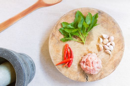 Ingredient of Stir-Fried Pork and Basil and Garlic and Chili on Wooden Cutting Board and Stone Mortar and Wood Paddle