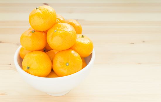 Chinese orange or mandarin or tangerine in white bowl on wood table