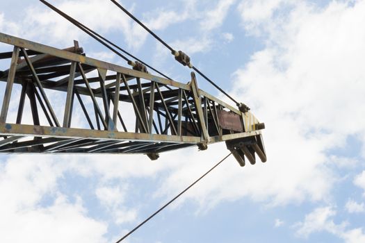 Crane head or iron structure and metal sling on blue sky background. Lifting machine heavy object in construction industry