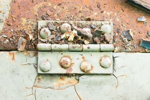 Old metal hinge and rust and rivet on old metal sheet of auto part in horizontal view. Grunge or retro or old background for industry design.