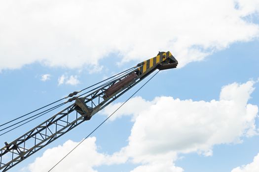 Crane head or iron structure and metal sling on blue sky background on side view. Lifting machine heavy object in construction industry