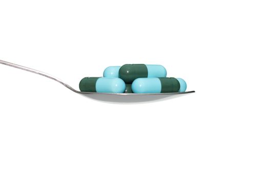 Green blue drug or pill or vitamin on metal Spoon isolated on white background. Concept about health care or medical or science including food concept.