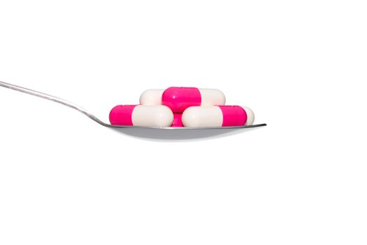 Pink White drug or pill or vitamin on metal Spoon isolated on white background. Concept about health care or medical or science including food concept.