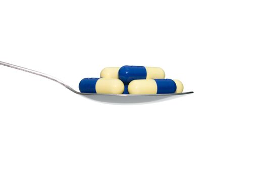 Blue Beige drug or pill or vitamin on metal Spoon isolated on white background. Concept about health care or medical or science including food concept.