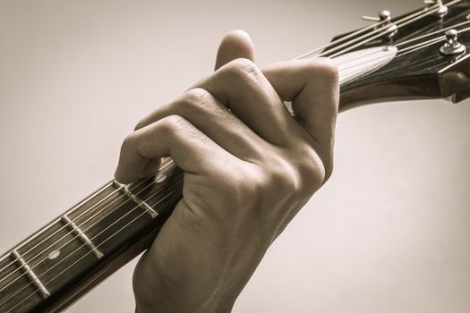 Guitar Player Hand or Musician Hand in C Major Chord on Acoustic Guitar String with soft natural light in close up view