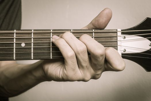 Guitar Player Hand or Musician Hand in C Major Chord on Acoustic Guitar String with soft natural light in close up view