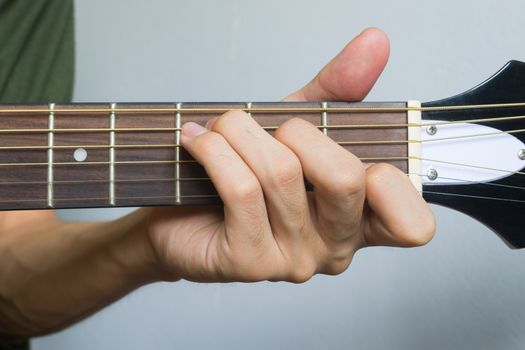 Guitar Player Hand or Musician Hand in C Major Chord on Acoustic Guitar String with soft natural light in close up view