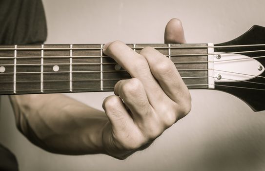 Guitar Player Hand or Musician Hand in G Major Chord on Acoustic Guitar String with soft natural light in close up view