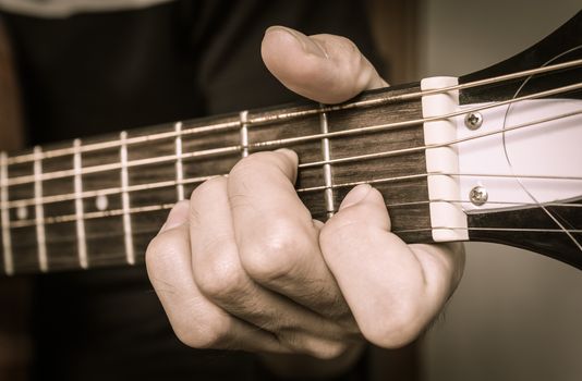 Guitar Player Hand or Musician Hand in A Minor Chord on Acoustic Guitar String with soft natural light in close up view