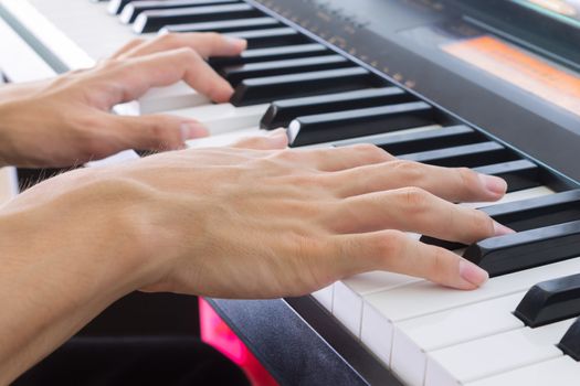 Hand of Piano Player on White Keys and Black Keys of Electric Piano in Crosswise View