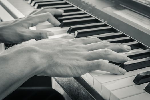 Hand of Piano Player on White Keys and Black Keys of Electric Piano in Crosswise View