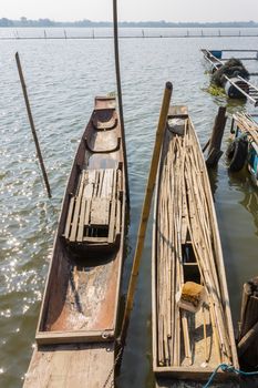 Wood Fishing Boat or Rowboat on Swamp with Wood Boat Pole Portrait. Wood fishing boat or rowboat or gondola of villagers stop at harbor or port. Wood fishing boat for tradition or culture 
scene with tree and bamboo