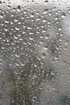 Drops of rain on the window, rainy day. Shallow DOF