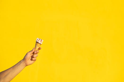 Ice cream with one hand on a yellow background