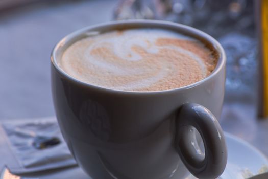 A white cup of coffee latte art before bokeh background