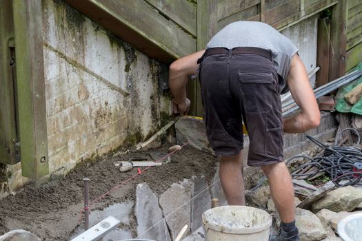 Workers at the laying and clipping of natural stone plates