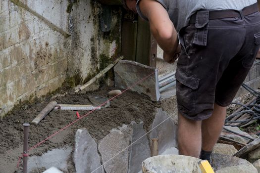 Workers at the laying and clipping of natural stone plates