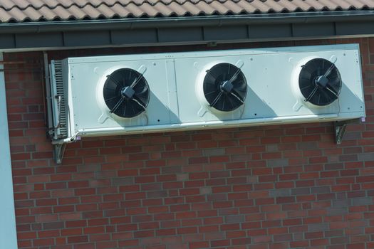 Compressor of an air conditioning mounted on a house wall.