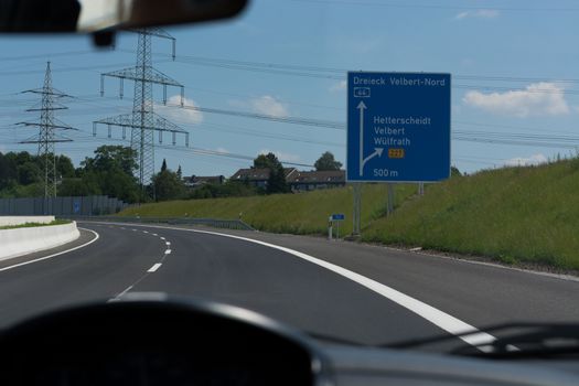 German motorway sign with inscription in German Driving direction to the cities - Velbert, Heiligenhaus, Wuelfrath and Hetterscheidt