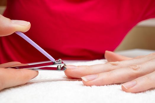 Woman cuts nails with nail cutter.Close-up Homemade manicure