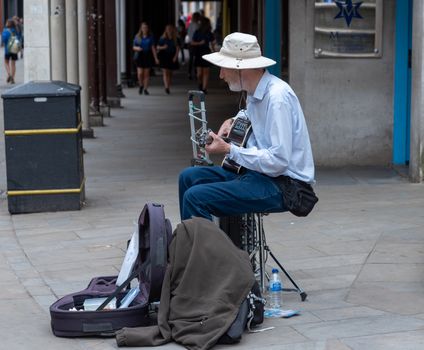 Winchester, England--July 17, 2018. A street musician plays his guitar in Winchester, England.