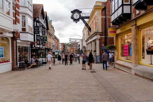 Winchester, United Kingdom--July 17, 2018. Wide angle shot of shoppers on the high street in Winchester, England on a summer afternoon.