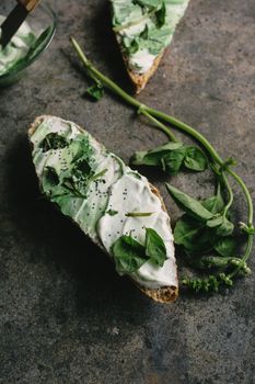 toast spread with cream cheese and basil, on grunge background