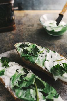 toast spread with cream cheese and basil, on grunge background