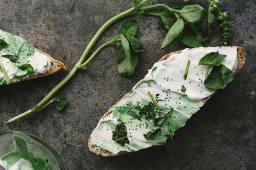 toast spread with cream cheese and basil, on grunge background