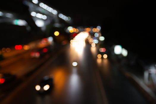 Abstract blurred traffic city of Night market on street light bokeh background. Bangkok, Thailand Cityscape at twilight time concept: focus in Motion blur,  Modern business building estate nightlife.