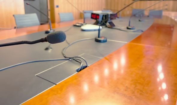 Microphone on a wooden table and empty chairs in a boardroom. Auditorium, meeting. Microphone on a wooden table and empty chairs in a boardroom. Auditorium, meeting.