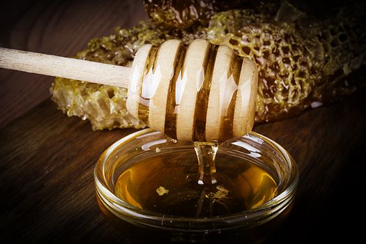 Yellow Honey and Honeycomb slice on a wooden table