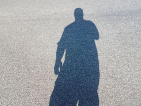 shadow or silhouette of man or male on sand at beach