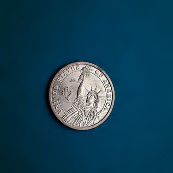 One dollar coin is placed in blue chart background