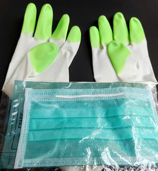 Chennai, India - July 13 2020: Hand gloves and mask kept in black chart as backgrounds used to wash and be safe during covid-19