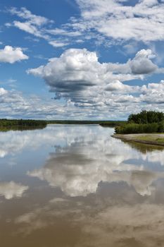 Beautiful summer landscape: view on Kamchatka River, beautiful clouds and reflection in water. Russia, Far East, Kamchatka Peninsula.