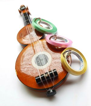 Chennai, India - July 14 2020: Guitar shape Key chain hanger with ribbons placed beautifully in white background for interior home decorations