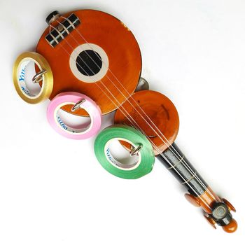 Chennai, India - July 14 2020: Guitar shape Key chain hanger with ribbons placed beautifully in white background for interior home decorations