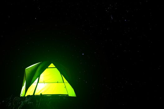 Camping green tent in forest at night and star background