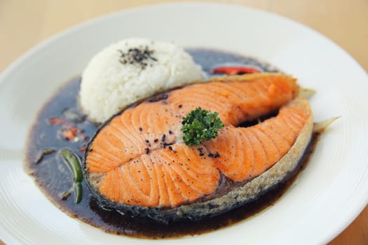 salmon black paper with rice on wood background