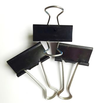 Three Black paper clips or chart clips arranged in white background