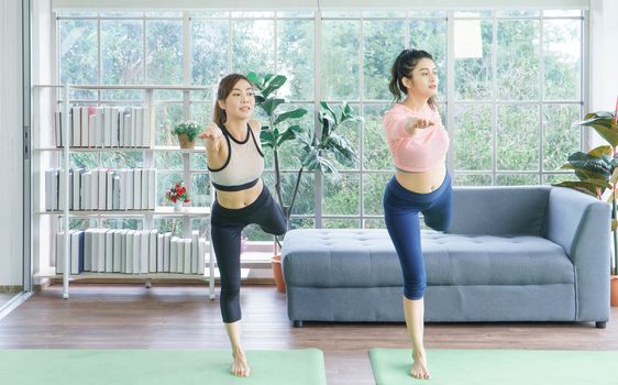 Balance the life of a young Asian woman attractive to exercise Stretching the yoga postures at home. sporty, wearing sportswear, training