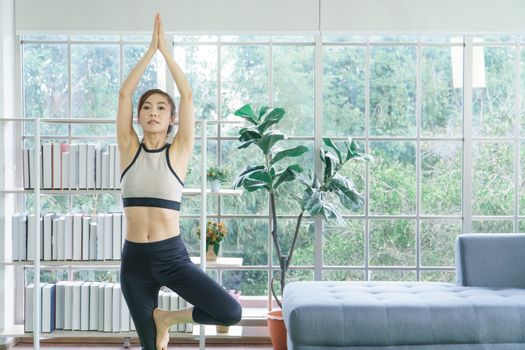 Balance the life of a young Asian woman attractive to exercise Stretching the yoga postures at home. sporty, wearing sportswear, training