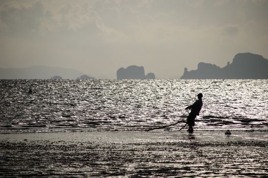 silhouette fisherman on the beach