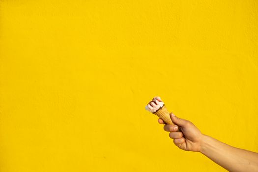 Ice cream with one hand on a yellow background