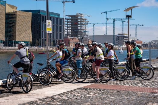 Dublin, Ireland -- July 10, 2018. A group of tourists on bicycles is looking over the River Liffey in Dublin, Ireland.